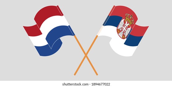 Crossed and waving flags of the Netherlands and Serbia