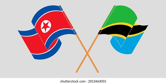 Crossed and waving flags of North Korea and Tanzania