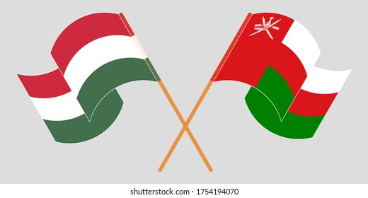 Crossed and waving flags of Oman and Hungary