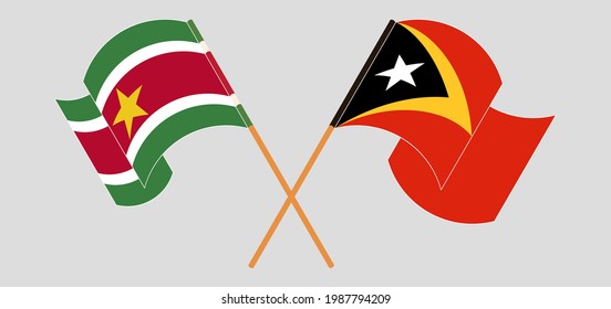 Crossed and waving flags of Suriname and East Timor