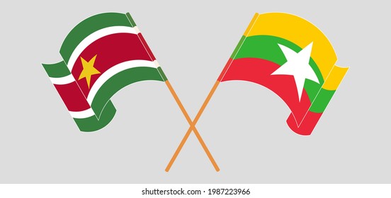 Crossed and waving flags of Suriname and Myanmar