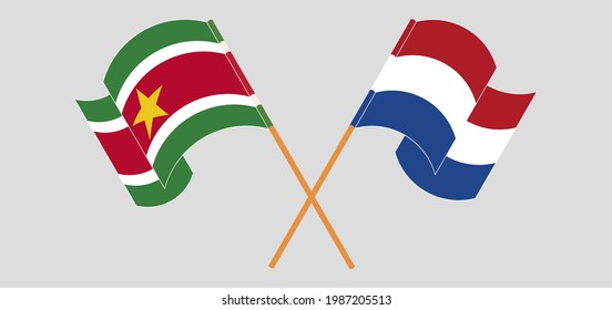 Crossed and waving flags of Suriname and the Netherlands