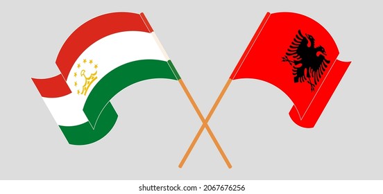 Crossed and waving flags of Tajikistan and Albania