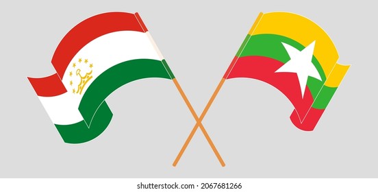 Crossed and waving flags of Tajikistan and Myanmar