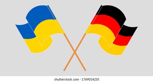 Banderas cruzadas y ondeando banderas de Ucrania y Alemania