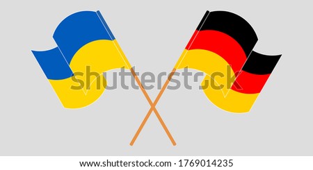 Crossed and waving flags of the Ukraine and Germany
