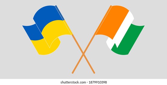 Crossed and waving flags of Ukraine and Republic of Ivory Coast