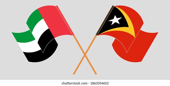Crossed and waving flags of the United Arab Emirates and East Timor