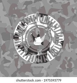 crown icon inside grey camouflaged emblem. 