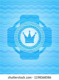 crown icon inside light blue water emblem background.