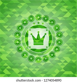 crown icon inside realistic green emblem. Mosaic background