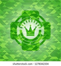 crown icon inside realistic green emblem. Mosaic background