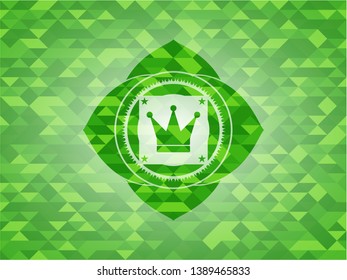 crown icon inside realistic green emblem. Mosaic background