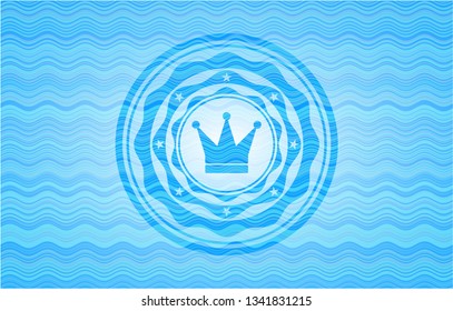 crown icon inside water representation emblem.