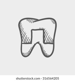 Crowned tooth sketch icon for web, mobile and infographics. Hand drawn vector dark grey icon isolated on light grey background.