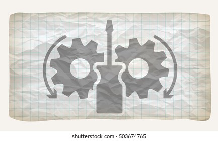 Crumpled graph paper with screwdriver and cogwheels