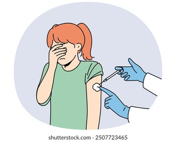 Crying little girl is afraid of injections and closes eyes during injection in shoulder and vaccination against measles or flu. Hands of doctor with syringe making injection to child