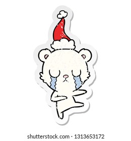 crying polar bear hand drawn distressed sticker cartoon of a wearing santa hat