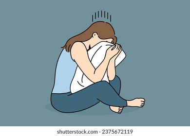 Crying woman sits hugging pillow and suffers because of problems in personal life or breaking up with boyfriend. Crying girl is experiencing psychological problems and needs help of psychotherapist