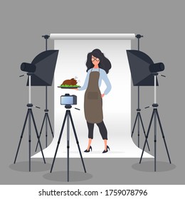 Culinary blogger. A woman in a kitchen apron holds a fried chicken on a tray. Camera on a tripod, softbox. The concept of a culinary blog or vlog. Vector.