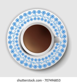 A cup of coffee with a decorative saucer