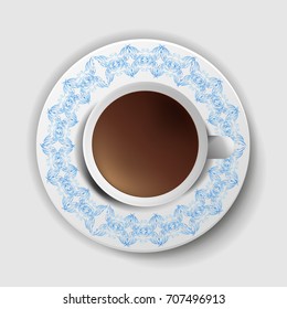 A cup of coffee with a decorative saucer