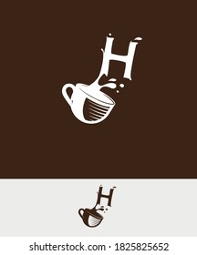 a cup of coffee with the letter H spilled
