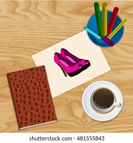 cup of coffee and a notepad with Colour pencils with vintage paper, painted shoes on wooden background 