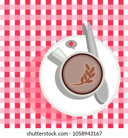 a cup of coffee on a checkered tablecloth
