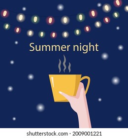 A cup of cozy hot coffee in hand against the background of the night starry sky and colorful lamps. Summer night party