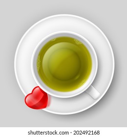 Cup of green tea with red heart on saucer. Top view