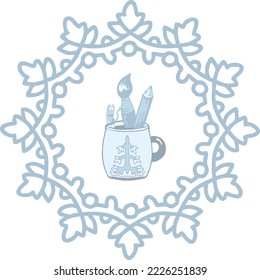 A cup with the image of a winter tree has become a stand for a brush and a pencil and a cat. Snowflake around.