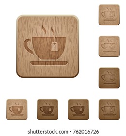 Cup of tea with teabag on rounded square carved wooden button styles