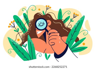 Curious woman with magnifying glass spying and hiding in bush working as detective and doing investigation. Curious girl employee of botanical greenhouse uses loupe to inspect rare plants 