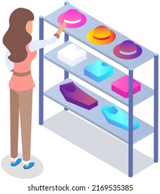 Customer choosing garments in womens clothing store. Female buyer buys hat, shirt and trousers during shopping. Purchaser service mall. Girl shopper stands near shelf with clothes in shop or boutique