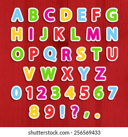 Cut vector alphabet sticker set in bright colors on wooden background. Vector illustration. Eps10.