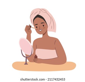 Cute african woman using serum for face. Daily skincare routine