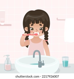 Una niña linda se cepilla los dientes en el baño. Niño de caricatura con cepillo de dientes frente al fregadero.