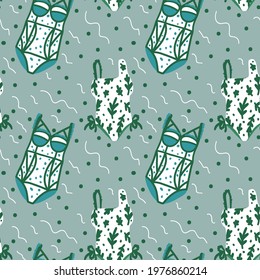 Cute background of summer swimsuits with greenery. Women's clothing for recreation and the beach, swimsuits, swimming trunks. Doodle clothing background for textiles. Vector illustration