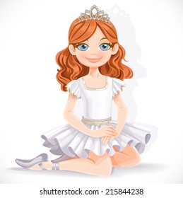 Cute ballerina girl in white dress and tiara sit on floor