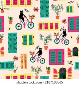 cute black cat on bicycle and a colorful windows