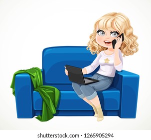 Cute blond girl sitting with laptop and phone on the small blue couch and buys something online  isolated on white background