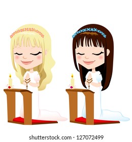 Cute blonde and brunette girls kneeling down praying on first communion ceremony