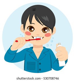 Cute boy brushing his teeth and holding toothpaste