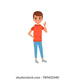 Cute boy character in stylish casual clothing hooded t-shirt with pocket and jeans. Kid posing with smiling face expression and waving hand. Cartoon flat vector