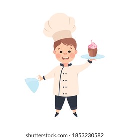 Cute Boy Chef Cook Holding Platter with Cupcake Dessert, Smiling Kid in Chef Uniform Cooking in Kitchen Cartoon Style Vector Illustration