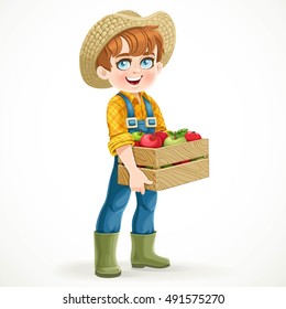 Cute boy farmer in jeans overalls and rubber boots holding a wooden box with apple isolated on white background