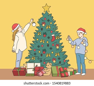 Cute boy and girl are decorating the Christmas tree. hand drawn style vector design illustrations. 