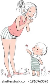 Cute boy gives his joyful mother a wildflower 