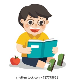A Cute Boy with glasses. He reading a book sitting on the floor.